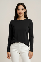 Woman wearing a navy long-sleeve top and white pants on a beige background