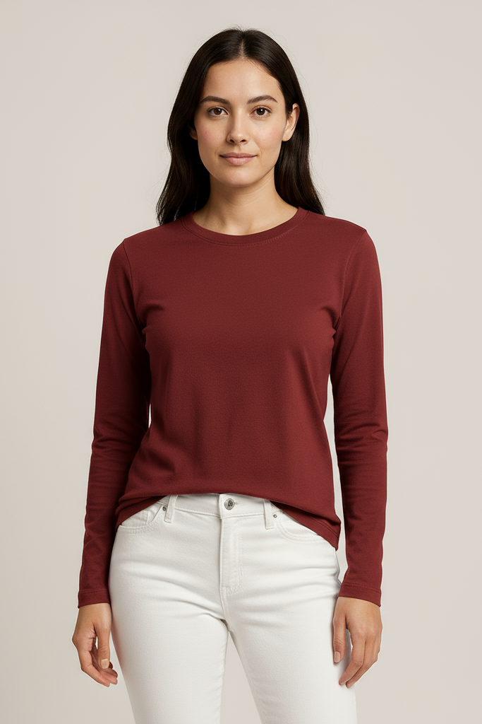 Woman wearing a burgundy long-sleeve top and white pants on a beige background