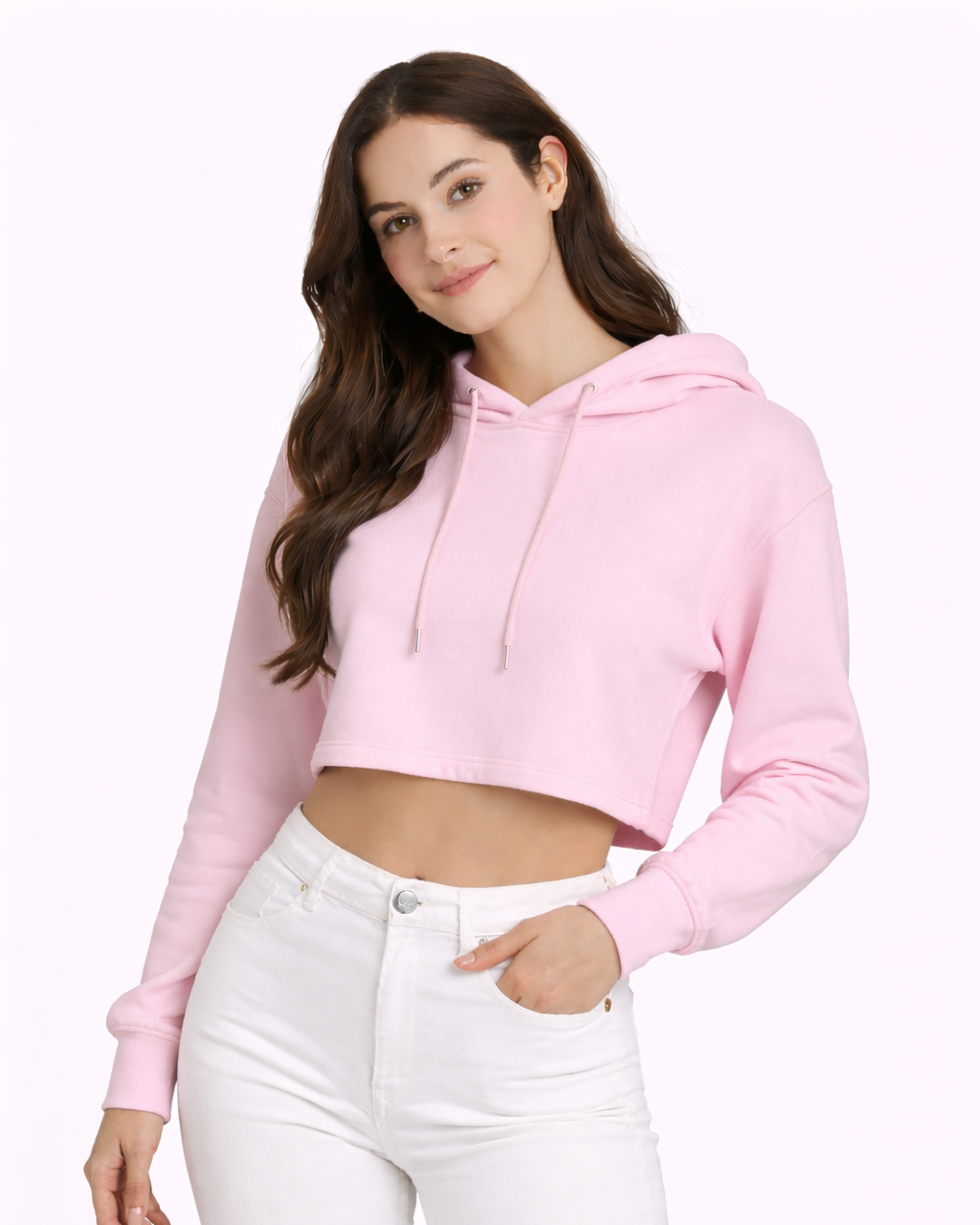 Woman wearing a pink cropped hoodie and white pants on a light pink background