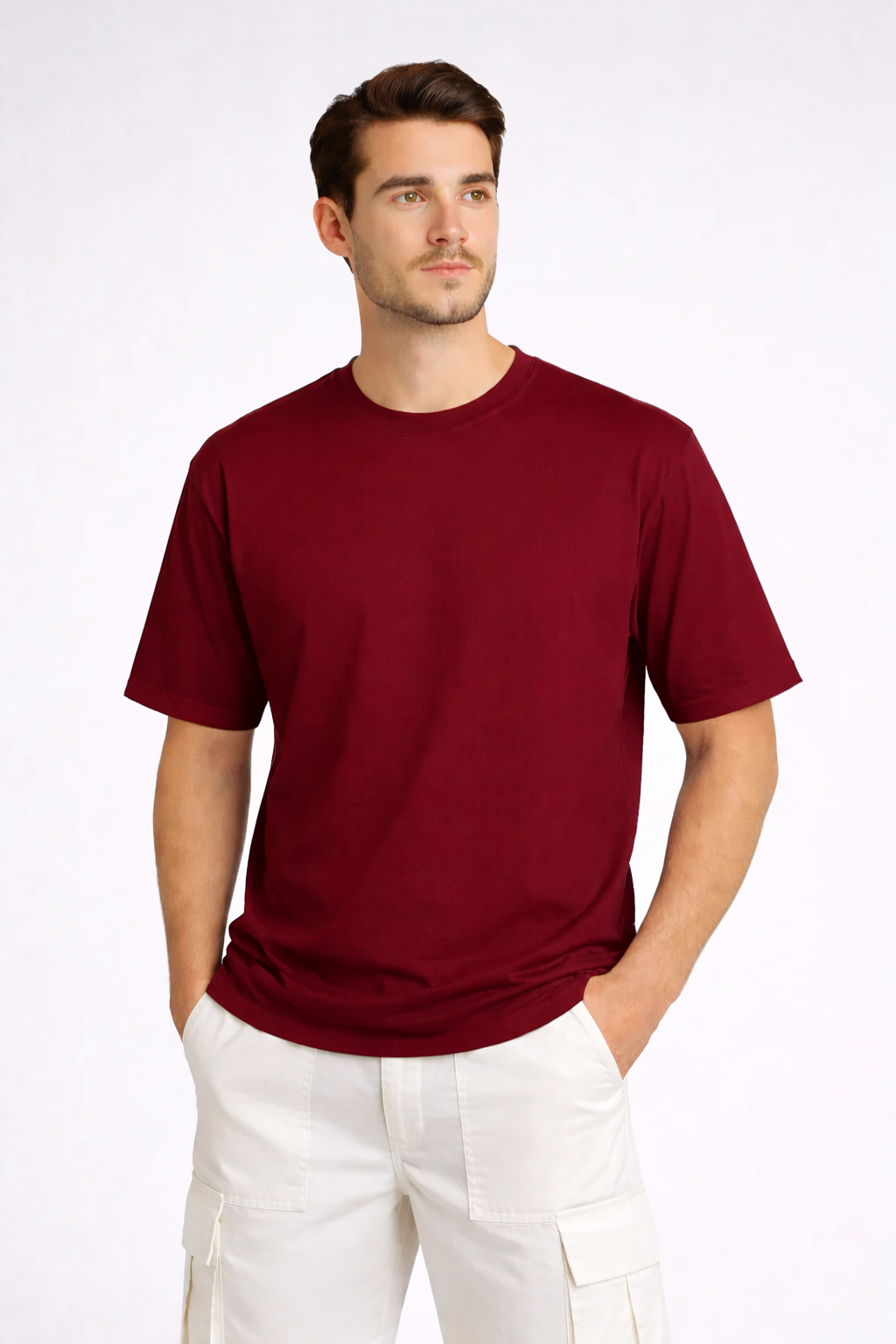 Man wearing a maroon t-shirt and white pants on a white background