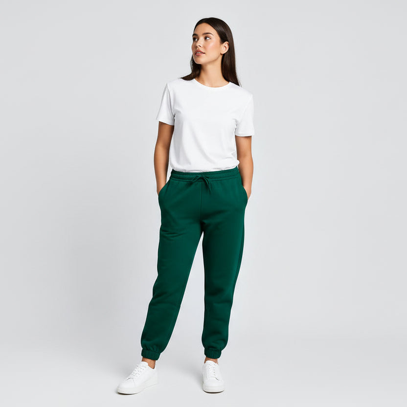 Woman wearing a white t-shirt and green pants on a light gray background